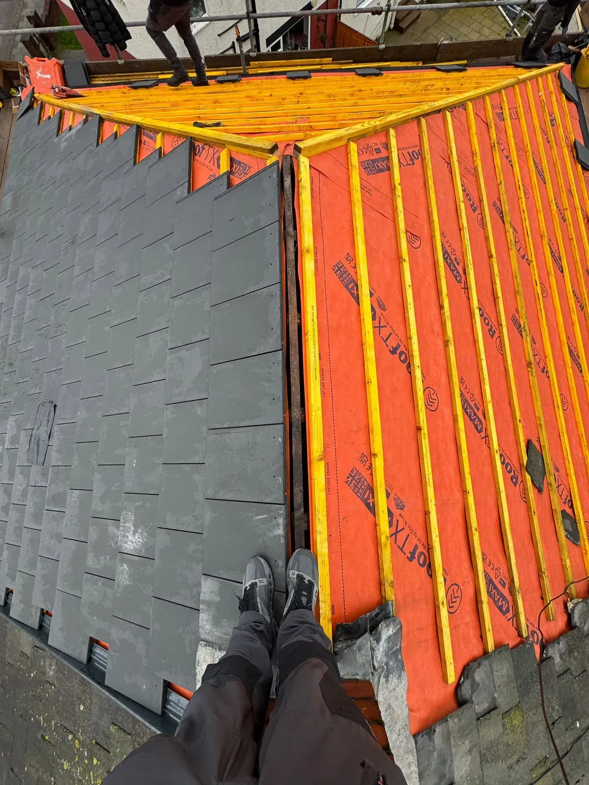 Roof replacement in progress, viewed from the ridge